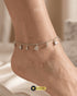 Close-up of a model's ankle wearing a shimmering square Zircon charm anklet in silver.