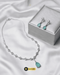 Mint green teardrop necklace and earrings set with a premium silver jewelry box on white silk fabric.