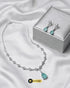 Mint green teardrop necklace and earrings set with a premium silver jewelry box on white silk fabric.