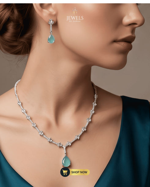 Model wearing the mint green signature necklace set with a dark teal outfit, showcasing the elegant jewelry drop.