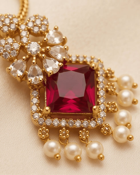Close-up of square-cut ruby pendant with AD stones and pearl drops in 22K gold polish - Jewels by Sarah Signature Collection