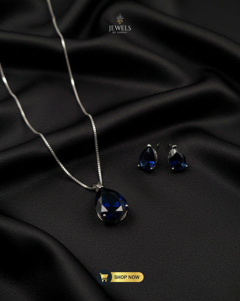 Royal blue faceted teardrop pendant set with silver chain.