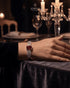 Woman wearing ruby red zircon statement bangle at candlelit table – Jewels by Sarah