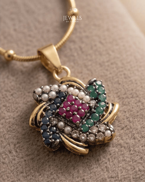 "Close-up of ruby, sapphire, emerald and pearl floral pendant on antique gold necklace by Jewels by Sarah"