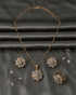 Premium AD diamond cut style jewelry set featuring a geometric floral pendant necklace, stud earrings, and ring on a grey satin background.