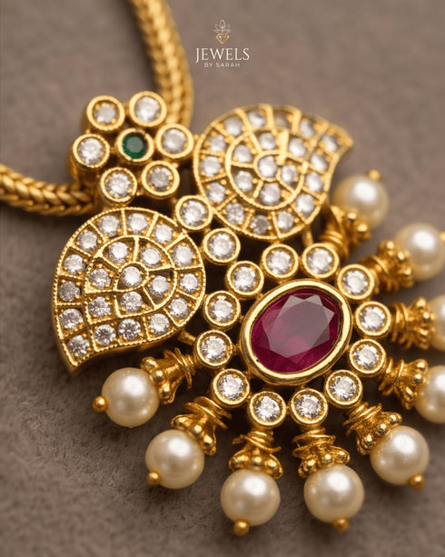 Close-up of ruby kemp stone pendant with AD stones and pearl drops in 22K gold polish - Jewels by Sarah