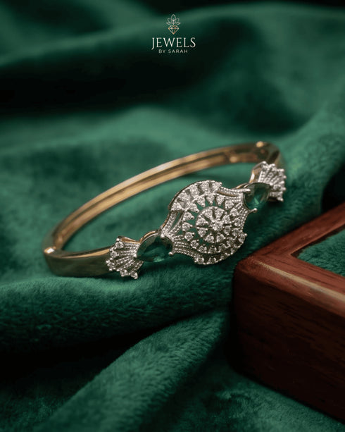 Gold emerald sunburst bangle styled on green velvet with wooden box – Jewels by Sarah