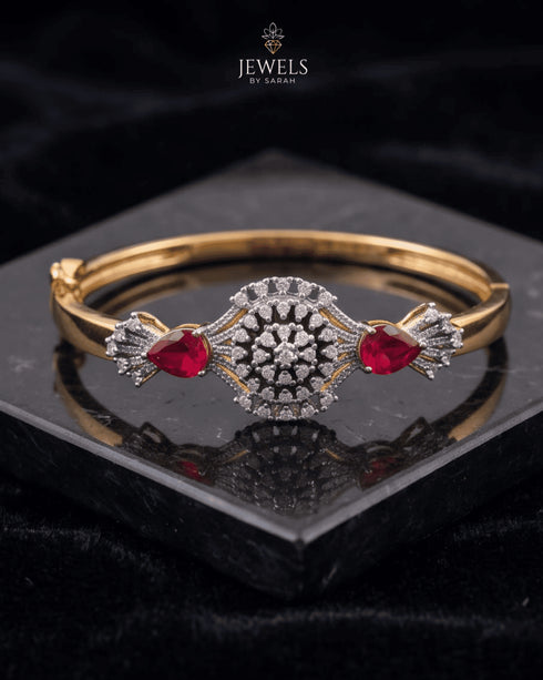 Gold ruby sunburst medallion bangle bracelet on reflective black surface – Jewels by Sarah