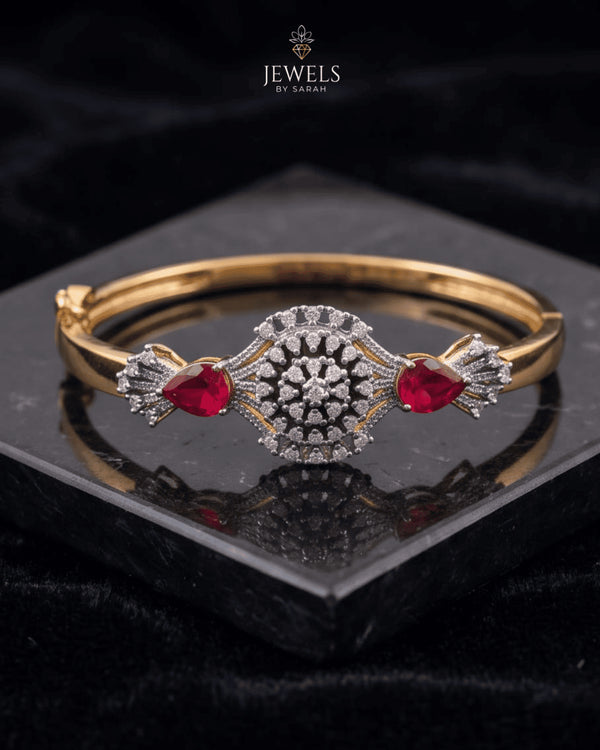 Gold ruby sunburst medallion bangle bracelet on reflective black surface – Jewels by Sarah