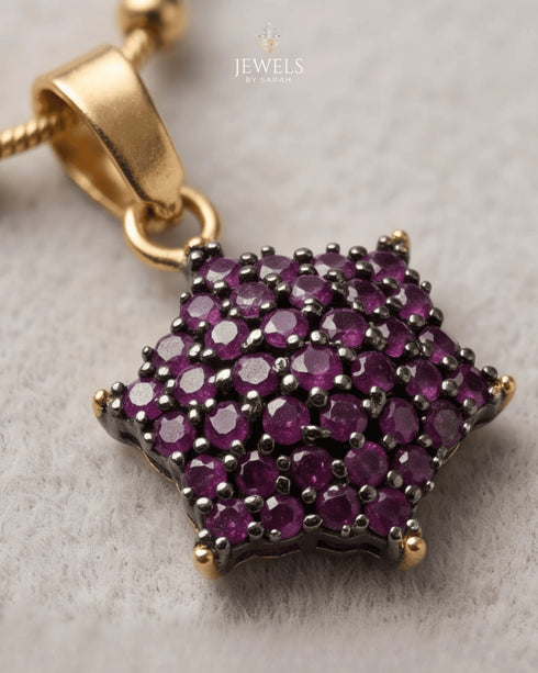"Close-up of ruby colored star cluster pendant on gold chain by Jewels by Sarah"