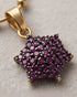 "Close-up of ruby colored star cluster pendant on gold chain by Jewels by Sarah"