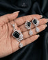 High-end emerald green emerald-cut pendant set adorned with intricate AD stone floral motifs on black silk drapery.