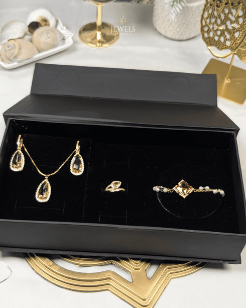"Gold teardrop pearl jewelry set displayed in black gift box packaging"