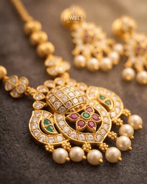"Close-up of South Indian antique gold peacock pendant with ruby, emerald and pearl detailing by Jewels by Sarah"