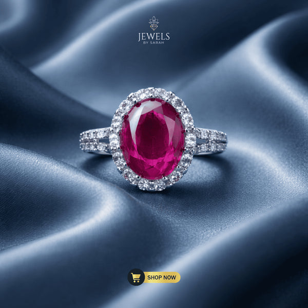 Signature ruby red oval halo ring with AD stones on luxury silk background