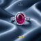 Signature ruby red oval halo ring with AD stones on luxury silk background