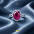 Signature ruby red oval halo ring with AD stones on luxury silk background