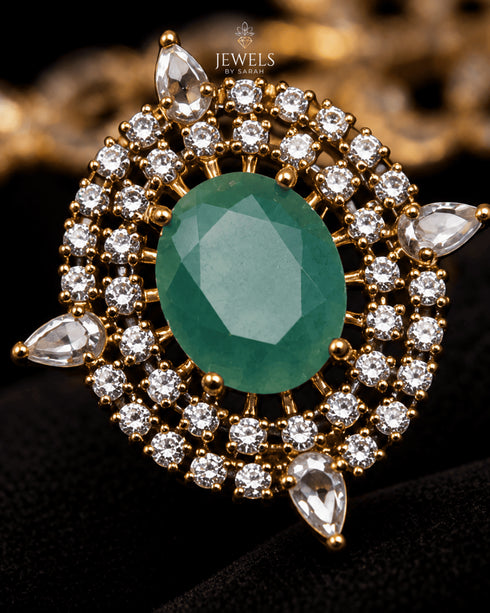 Close-up of green centerstone and AD stone halo on Jadau pendant - Jewels by Sarah 22K gold polish