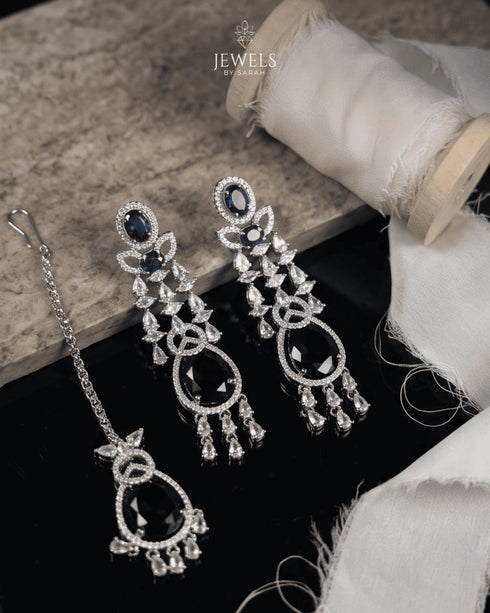 Sapphire blue stone drop earrings and tikka with AD stone detailing on marble