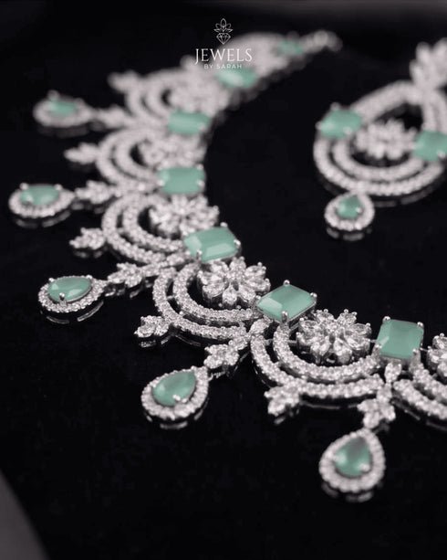 Close up view of mint green stone necklace with floral AD design