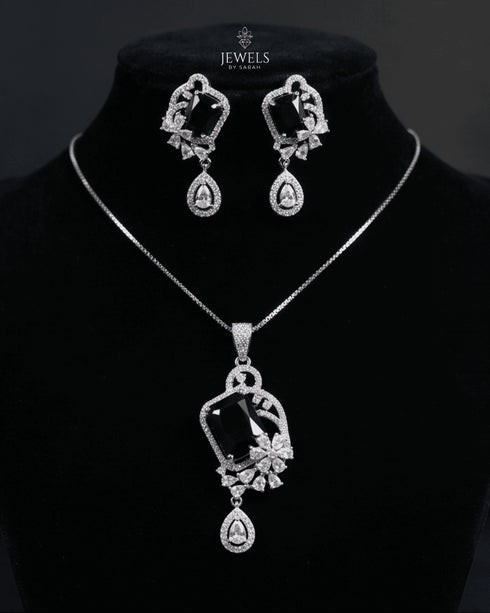 Premium black gemstone pendant set beautifully draped on a luxury matte charcoal mannequin bust under dramatic studio lighting.