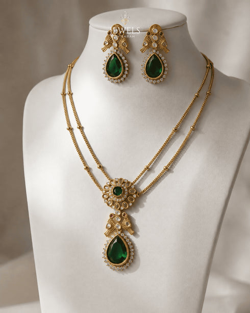 South Indian layered emerald necklace set with matching earrings displayed on mannequin bust - Jewels by Sarah