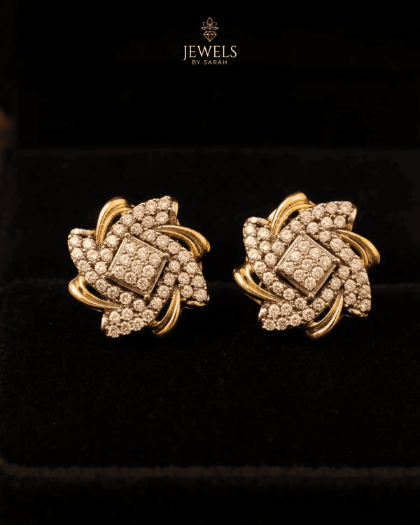"Swirling crystal floral stud earrings with two-tone gold finish on black velvet by Jewels by Sarah"