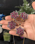 Premium ruby red floral pendant necklace and matching stud earrings displayed on a hand to show scale.