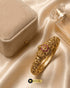 Luxury display of Jewels by Sarah signature gold bangle next to velvet jewelry box and perfume.