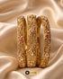 Trio of Jewels by Sarah 24K gold plated signature bangles with ruby zircons on gold silk.