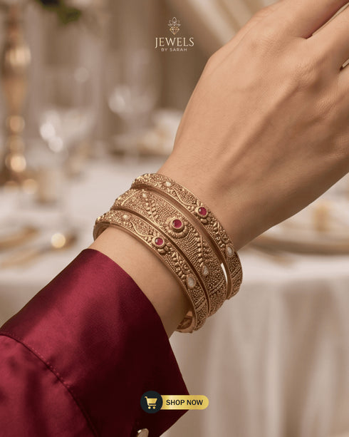 Model wearing three stacked ruby and AD stone 24K gold plated bangles.