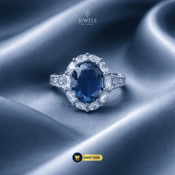 Signature Royal oval sapphire blue ring with marquise halo on blue silk