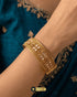 Model wearing the Mughal Flora 24K gold plated broad bangle with a teal traditional dress.