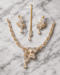 "Golden butterfly necklace set with mint pink stones, earrings and tikka on marble background by Jewels by Sarah"