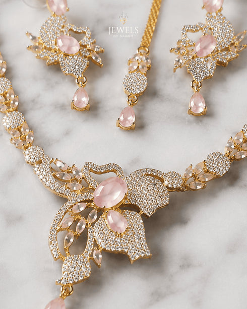 "Close-up of mint pink stone and AD crystal butterfly pendant on golden necklace set"
