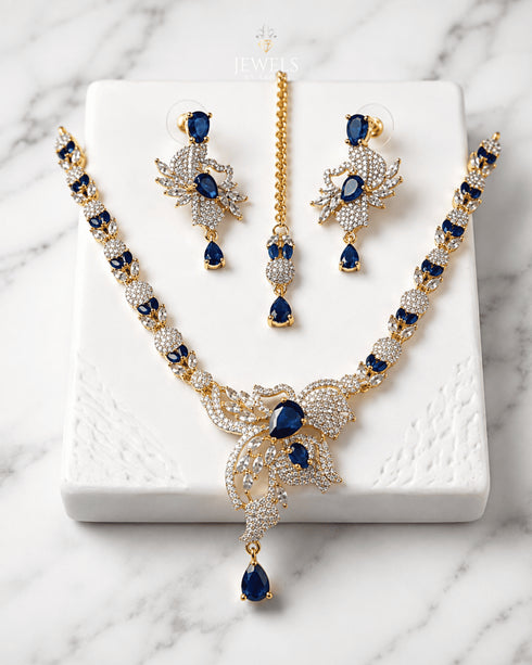 "Royal blue gold AD butterfly necklace set with tikka and earrings on marble by Jewels by Sarah"