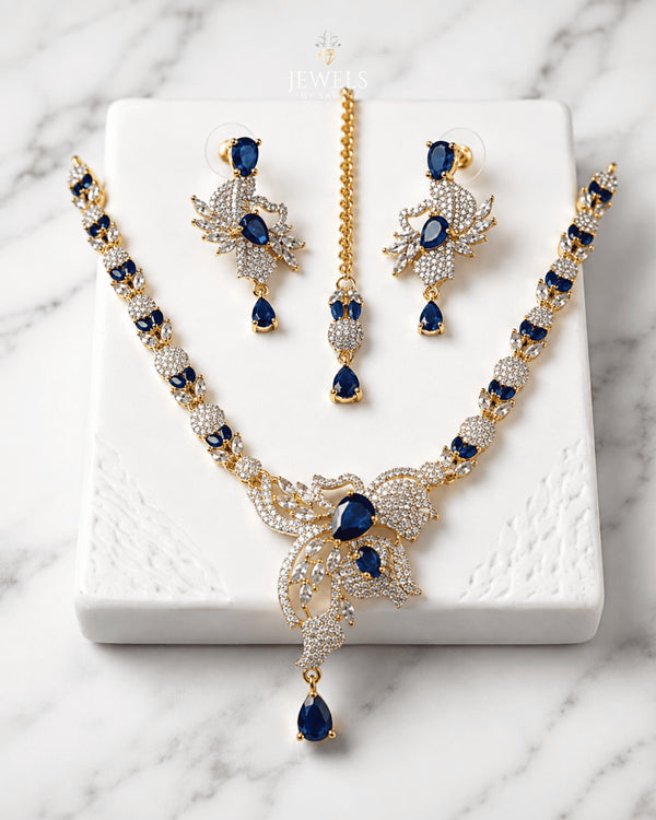 "Royal blue gold AD butterfly necklace set with tikka and earrings on marble by Jewels by Sarah"