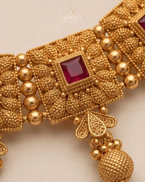 Close up of South Indian choker necklace ruby stone and textured gold detail