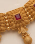 Close up of South Indian choker necklace ruby stone and textured gold detail