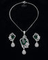 luxury flat lay of the emerald green emerald-cut pendant set on a rich, seamless black background.