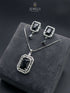 Elegant black onyx color jewelry set with emerald-cut pendant and drop earrings on grey velvet box.