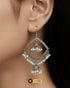 Model wearing large traditional silver geometric pearl jhumka earrings.