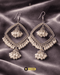 Traditional antique silver jhumka earrings with white pearls on a grey velvet background.