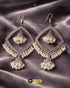 Traditional antique silver jhumka earrings with white pearls on a grey velvet background.