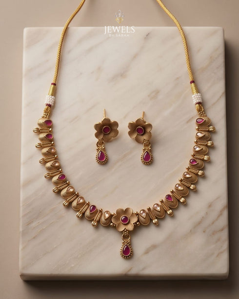 South Indian antique gold necklace and earring set on marble background