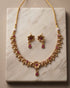 South Indian antique gold necklace and earring set on marble background