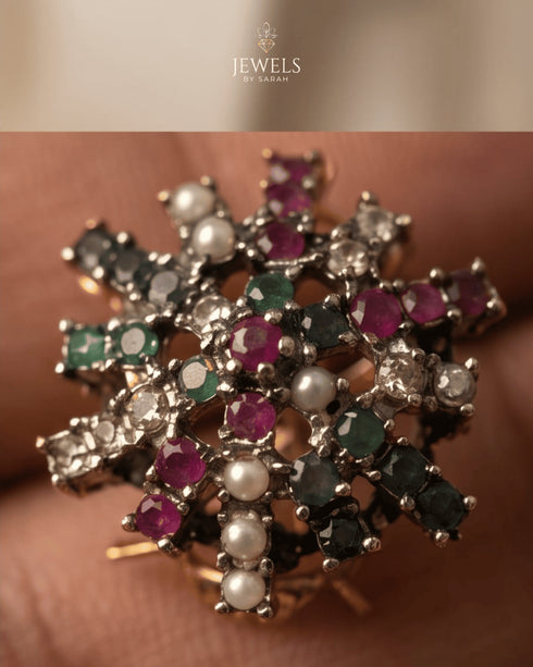 Close up of multi color stone snowflake stud earring with pearl detail