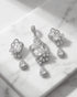 The Aura crystal clear luxury pendant set displayed flat on a high-end textured white marble surface under soft natural light.