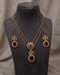 South Indian ruby peacock necklace set with matching earrings displayed on mannequin bust - Jewels by Sarah