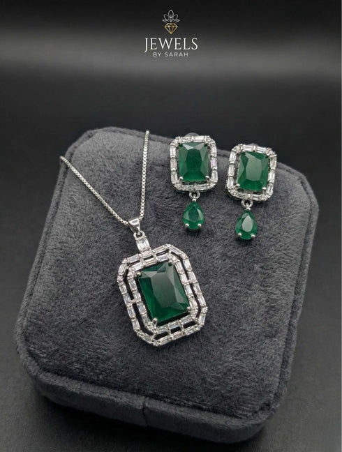 Silver necklace and earring set with emerald green rectangular stone and baguette crystal halo.